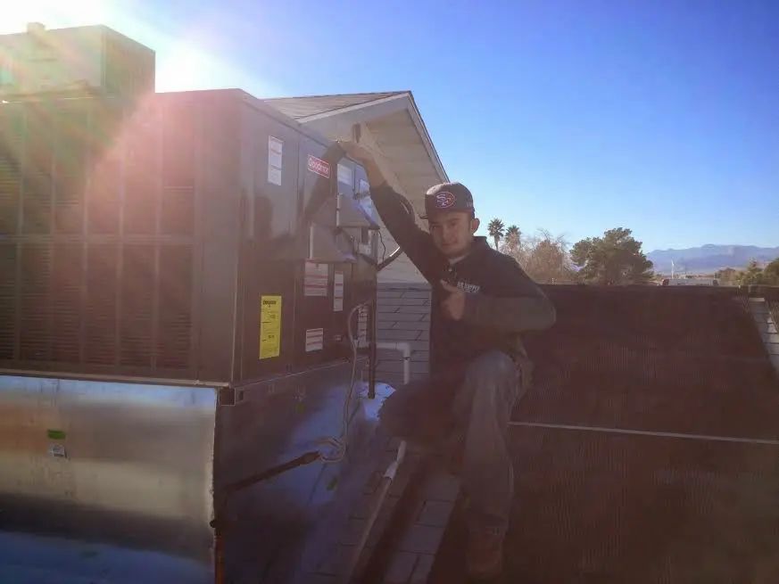 HVAC technician performing HVAC Inspection on a rooftop unit in North Bend